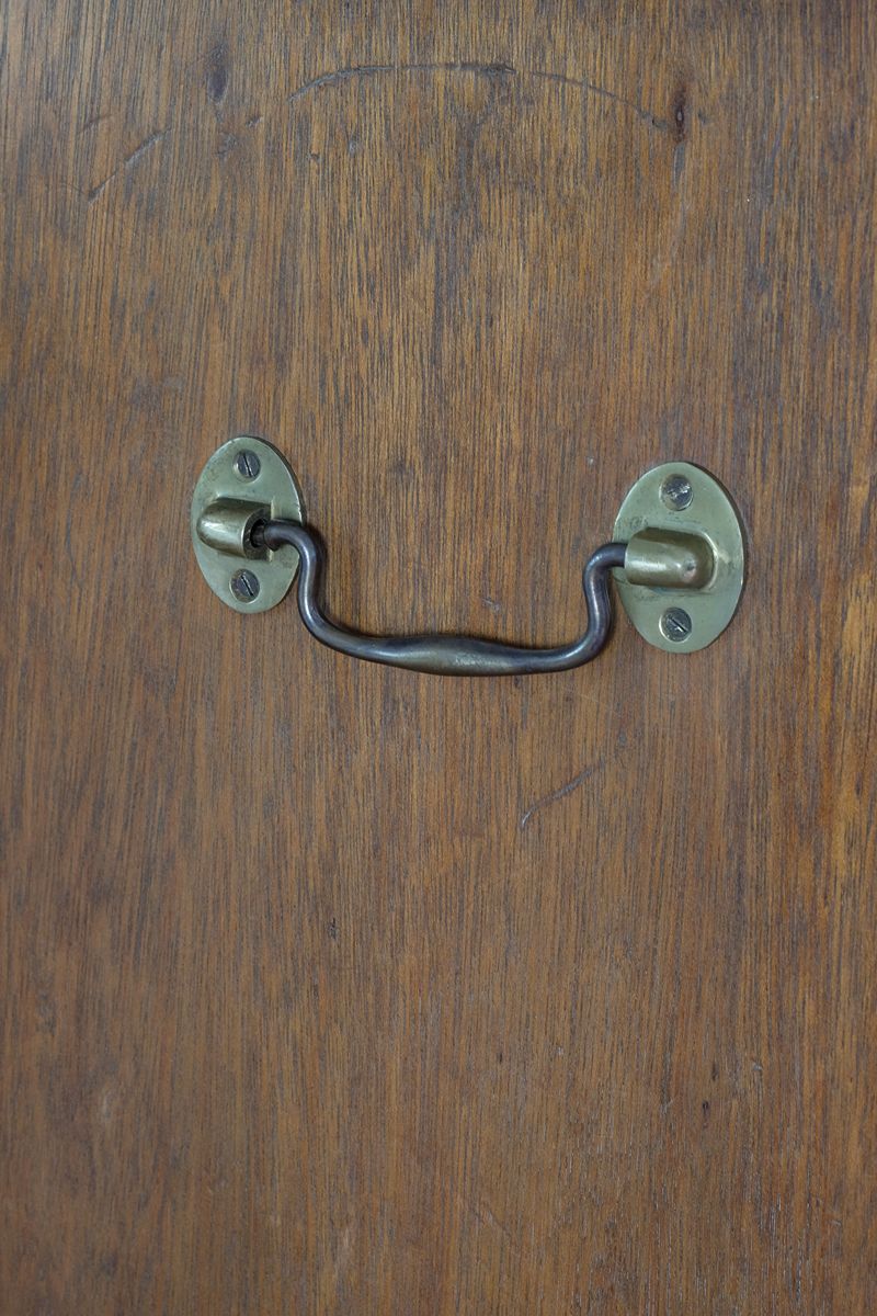 Side view of mahogany campaign chest showing carrying handle and shaped bracket feet
