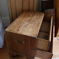 Close view of rounded drawer front and recessed brass campaign pull