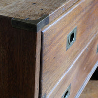 Close view of rounded drawer front and recessed brass campaign pull