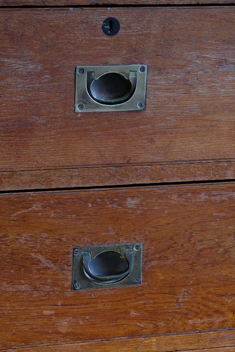 Close-up of recessed brass campaign drawer handle and original keyhole escutcheon.
