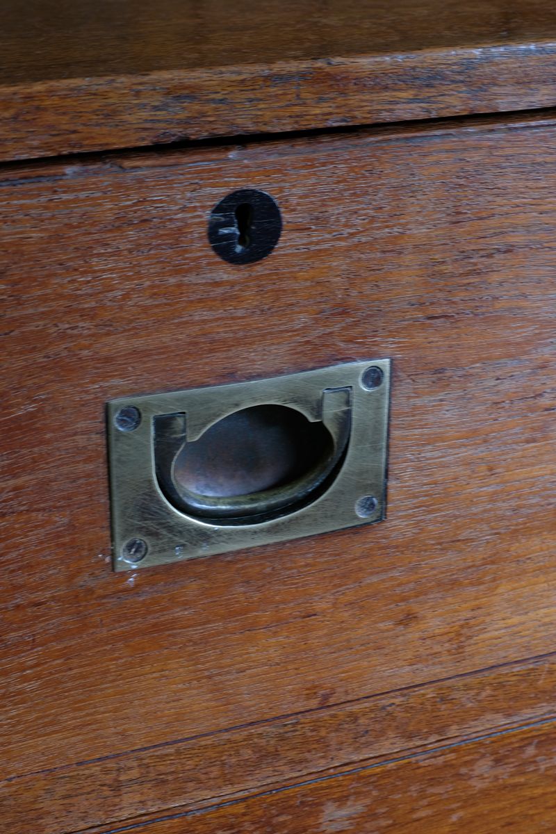 Close-up of recessed brass campaign drawer handle and original keyhole escutcheon.