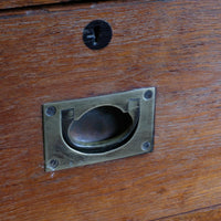 Close-up of recessed brass campaign drawer handle and original keyhole escutcheon.