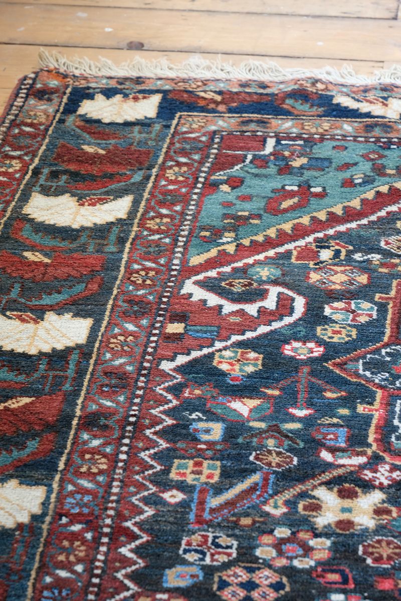 Early 20th century Persian Qashqai wool rug with indigo field, three medallions and blue-green corners, 244 × 159 cm