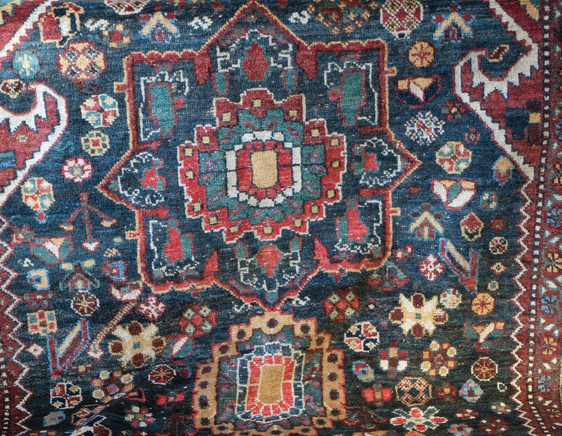 Early 20th century Persian Qashqai wool rug with indigo field, three medallions and blue-green corners, 244 × 159 cm