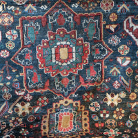 Early 20th century Persian Qashqai wool rug with indigo field, three medallions and blue-green corners, 244 × 159 cm
