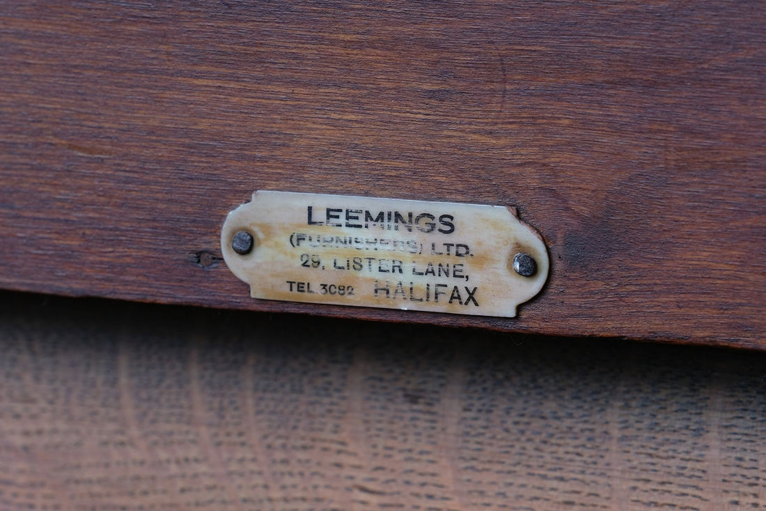 Leemings Halifax ivorine furniture supplier label on the Arts & Crafts oak console table by Beresford & Hicks with two drawers and shaped trestle supports