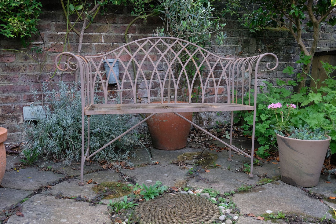 Painted wrought iron garden bench with Gothic arch back, scroll armrests and slatted seat