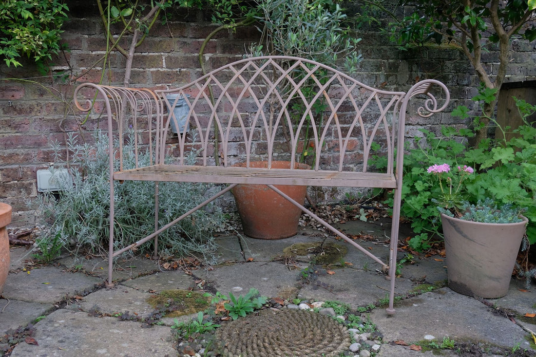 Painted wrought iron garden bench with Gothic arch back, scroll armrests and slatted seat