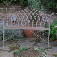 Painted wrought iron garden bench with Gothic arch back, scroll armrests and slatted seat