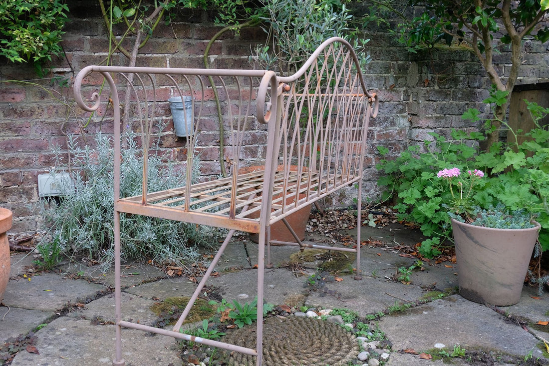 Painted wrought iron garden bench with Gothic arch back, scroll armrests and slatted seat