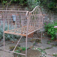 Painted wrought iron garden bench with Gothic arch back, scroll armrests and slatted seat