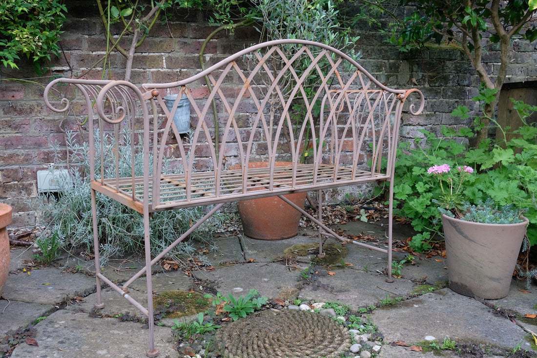 Painted wrought iron garden bench with Gothic arch back, scroll armrests and slatted seat