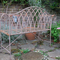 Painted wrought iron garden bench with Gothic arch back, scroll armrests and slatted seat