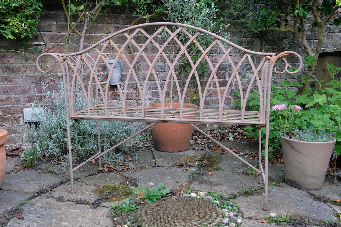 Painted wrought iron garden bench with Gothic arch back, scroll armrests and slatted seat