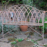Painted wrought iron garden bench with Gothic arch back, scroll armrests and slatted seat