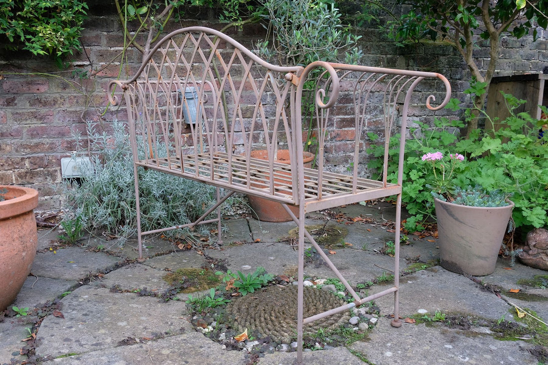 Painted wrought iron garden bench with Gothic arch back, scroll armrests and slatted seat
