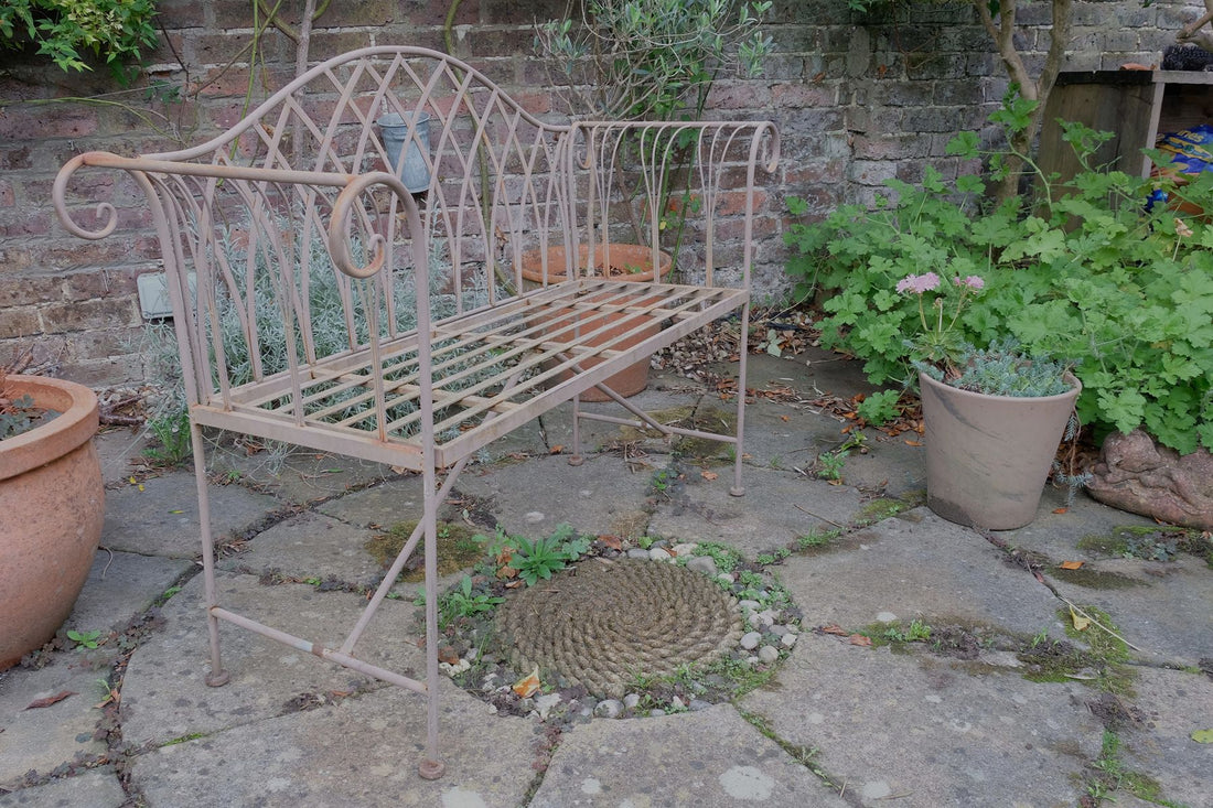 Painted wrought iron garden bench with Gothic arch back, scroll armrests and slatted seat