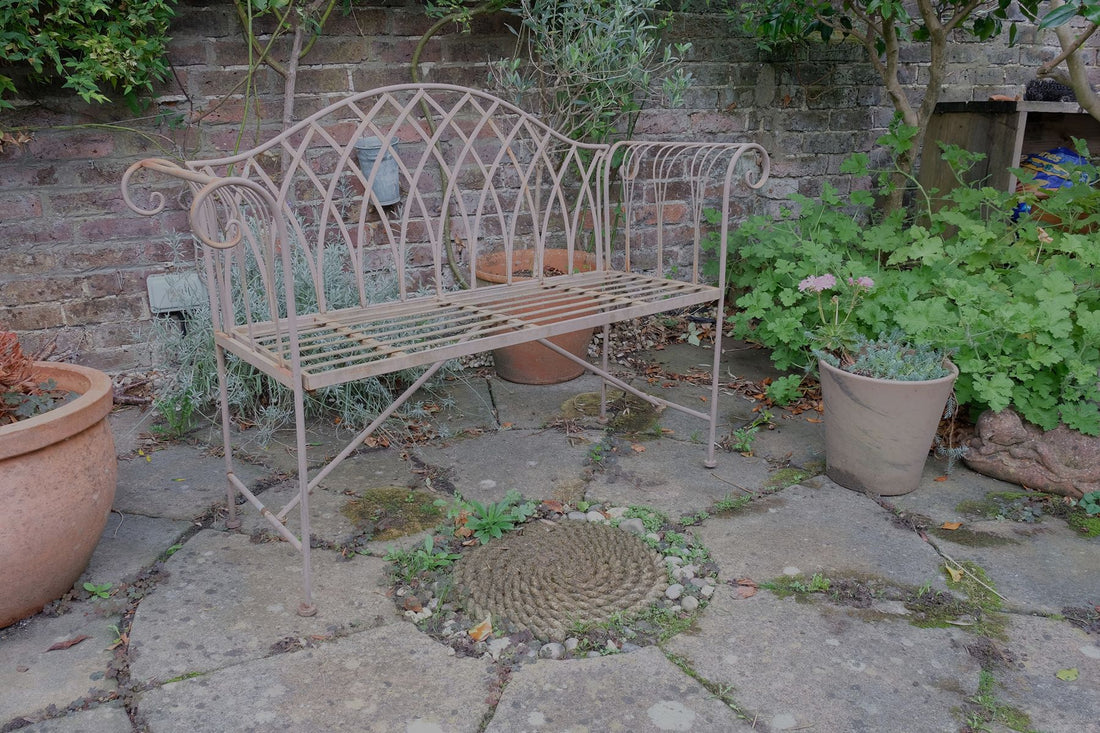 Painted wrought iron garden bench with Gothic arch back, scroll armrests and slatted seat