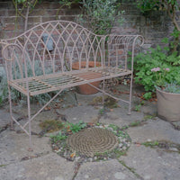 Painted wrought iron garden bench with Gothic arch back, scroll armrests and slatted seat