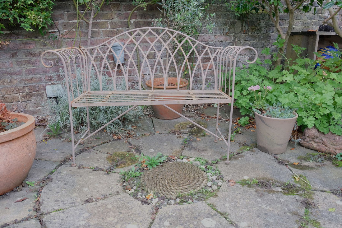 Painted wrought iron garden bench with Gothic arch back, scroll armrests and slatted seat
