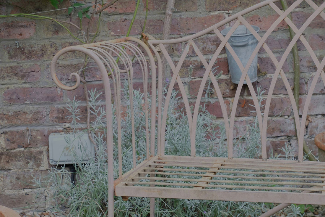 Painted wrought iron garden bench with Gothic arch back, scroll armrests and slatted seat