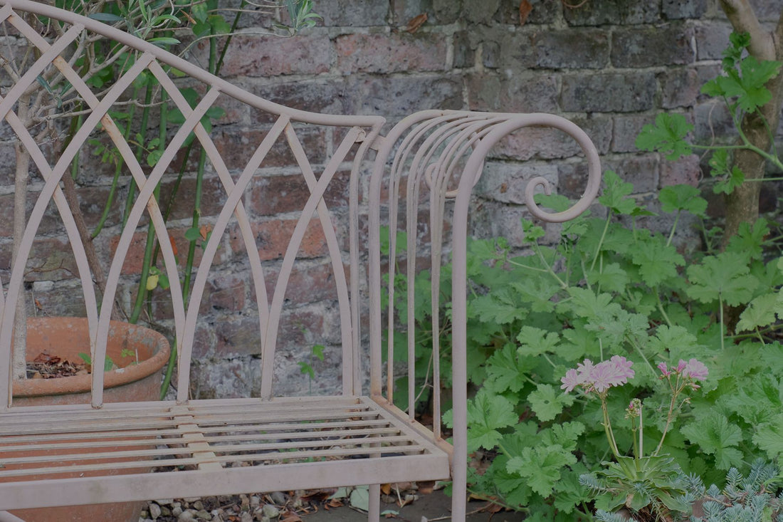 Painted wrought iron garden bench with Gothic arch back, scroll armrests and slatted seat