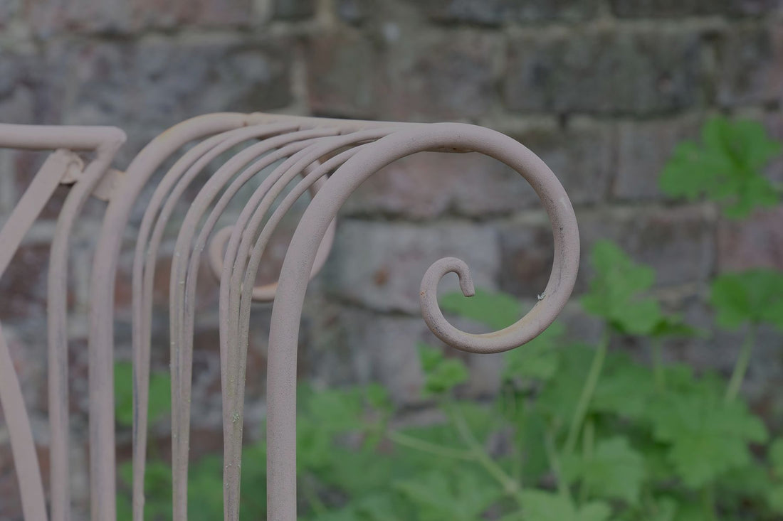 Painted wrought iron garden bench with Gothic arch back, scroll armrests and slatted seat