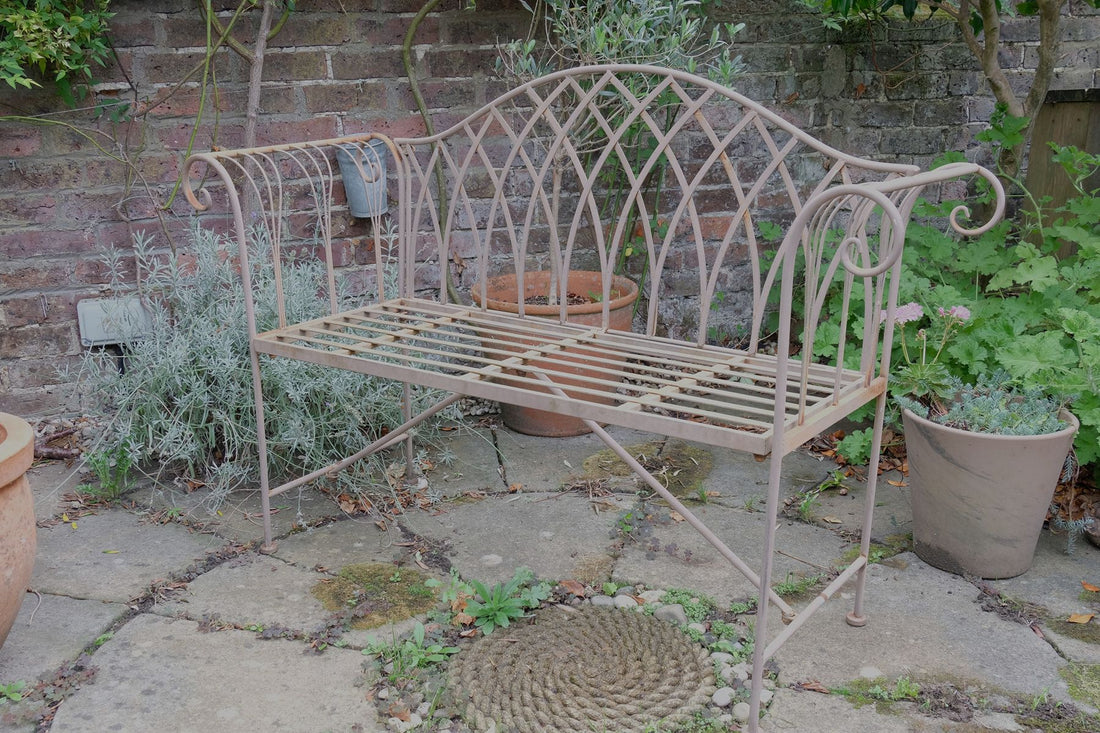 Painted wrought iron garden bench with Gothic arch back, scroll armrests and slatted seat