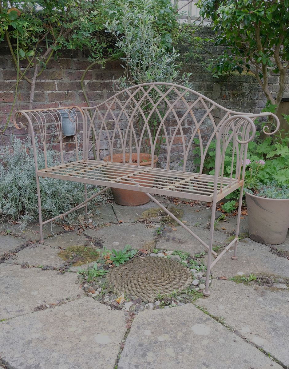 Painted wrought iron garden bench with Gothic arch back, scroll armrests and slatted seat