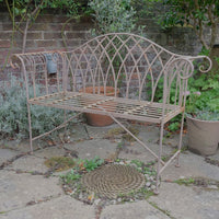 Painted wrought iron garden bench with Gothic arch back, scroll armrests and slatted seat