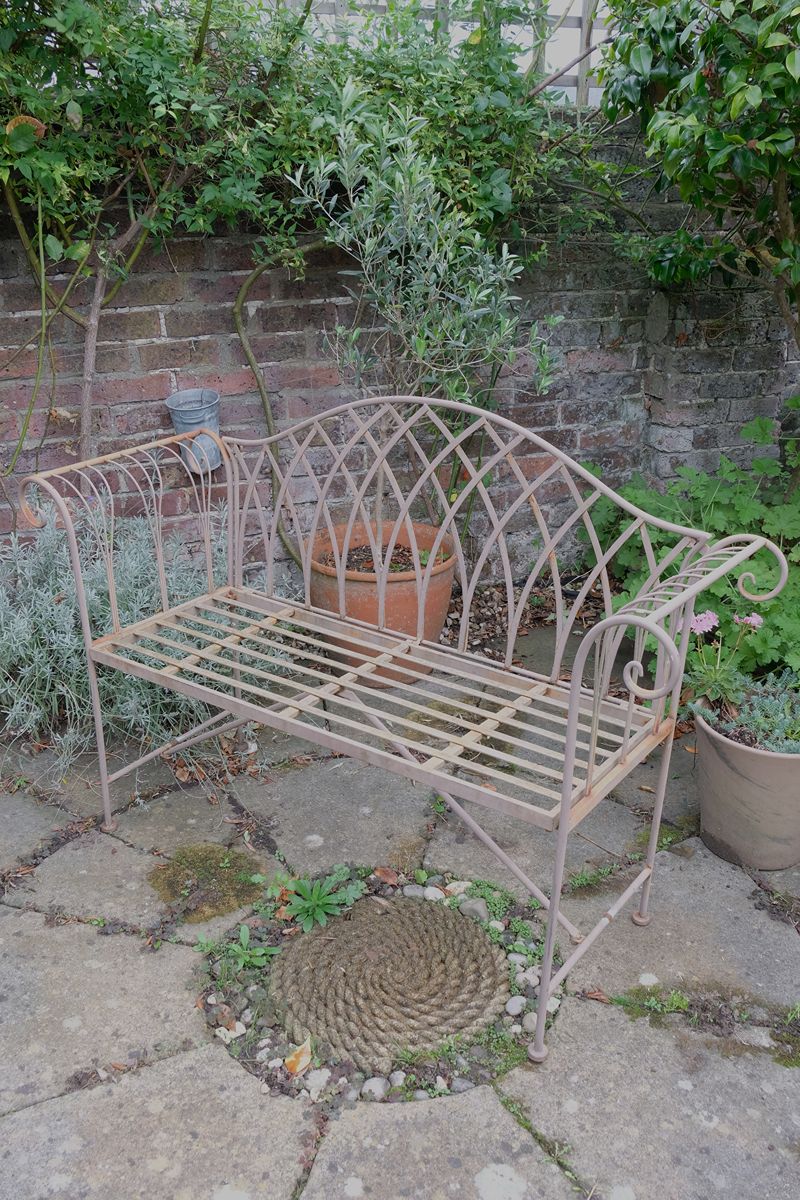 Painted wrought iron garden bench with Gothic arch back, scroll armrests and slatted seat