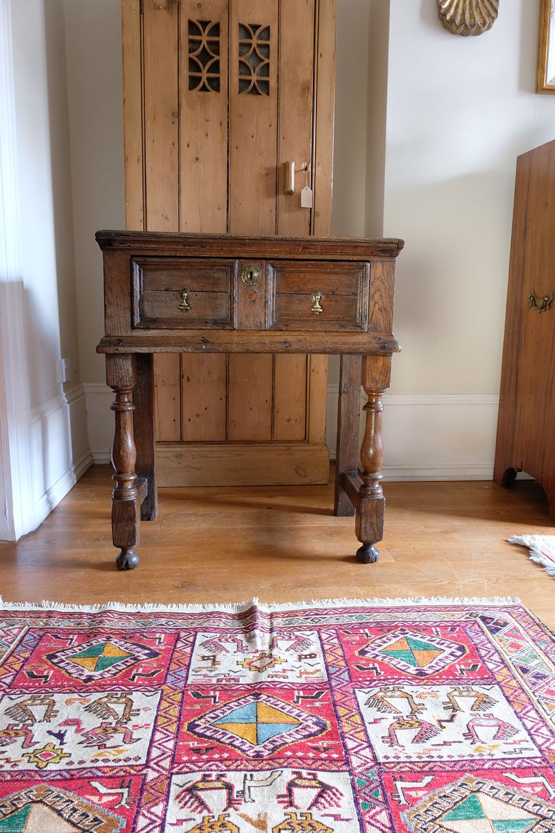 18th century country oak side table with a single panelled drawer, brass handles and baluster-turned front legs
