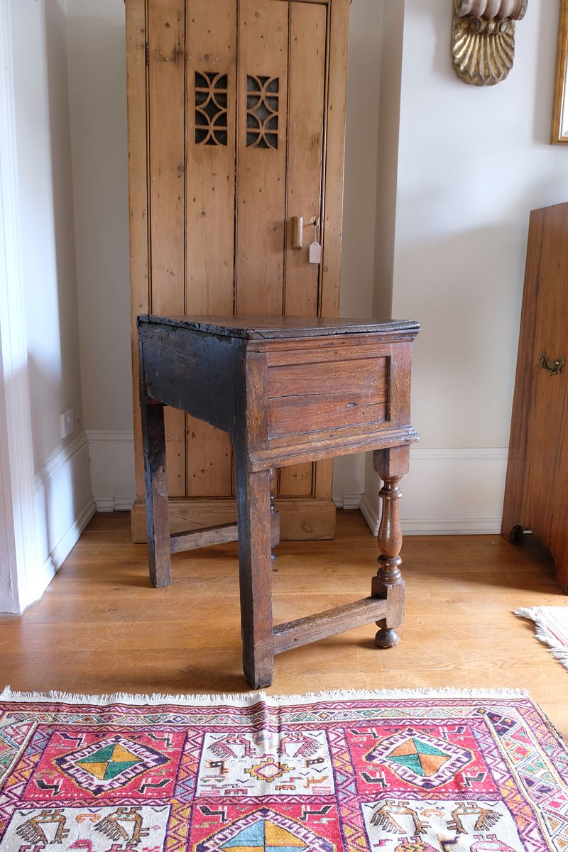 Side panel view - 18th century country oak side table with a single panelled drawer, brass handles and baluster-turned front legs