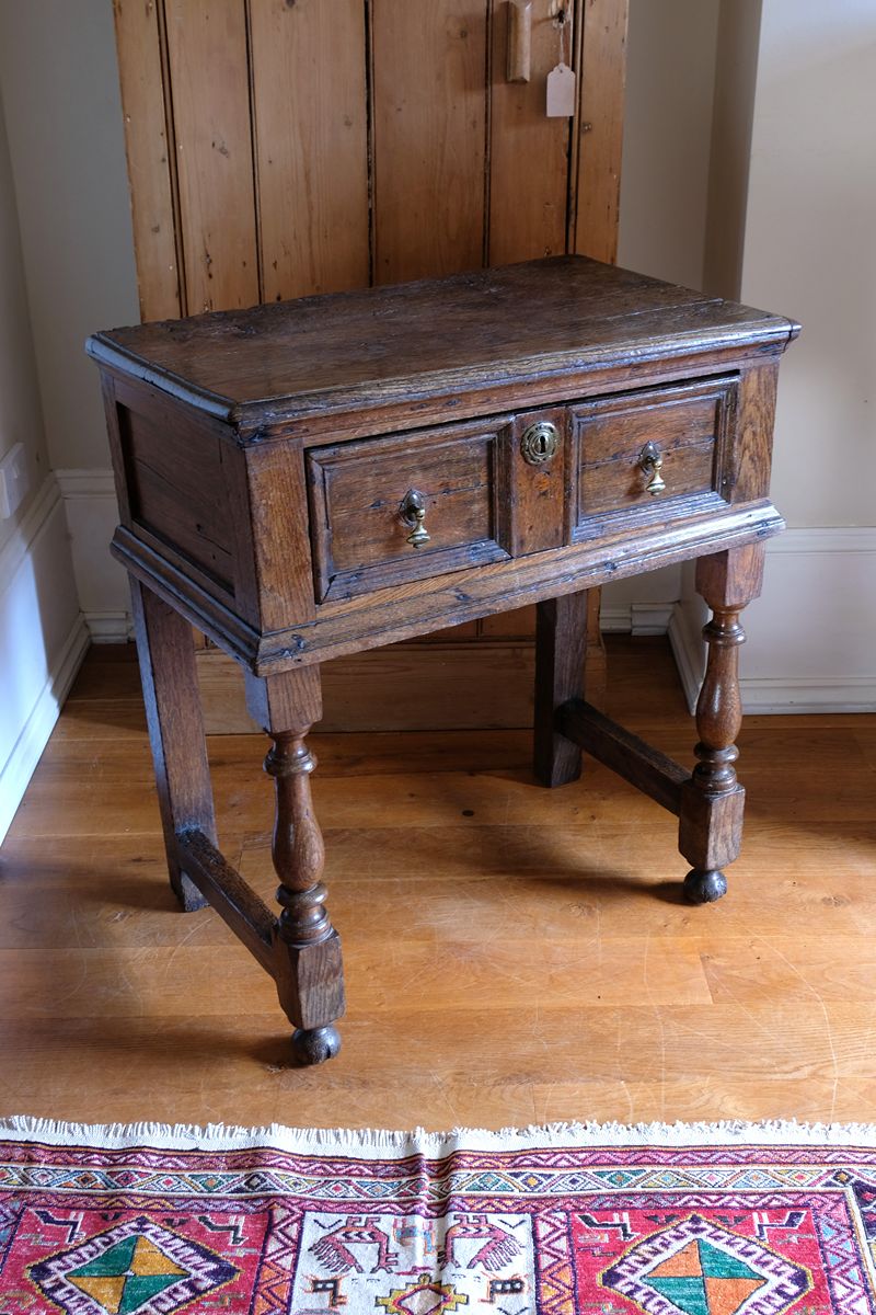 18th century country oak side table with a single panelled drawer, brass handles and baluster-turned front legs