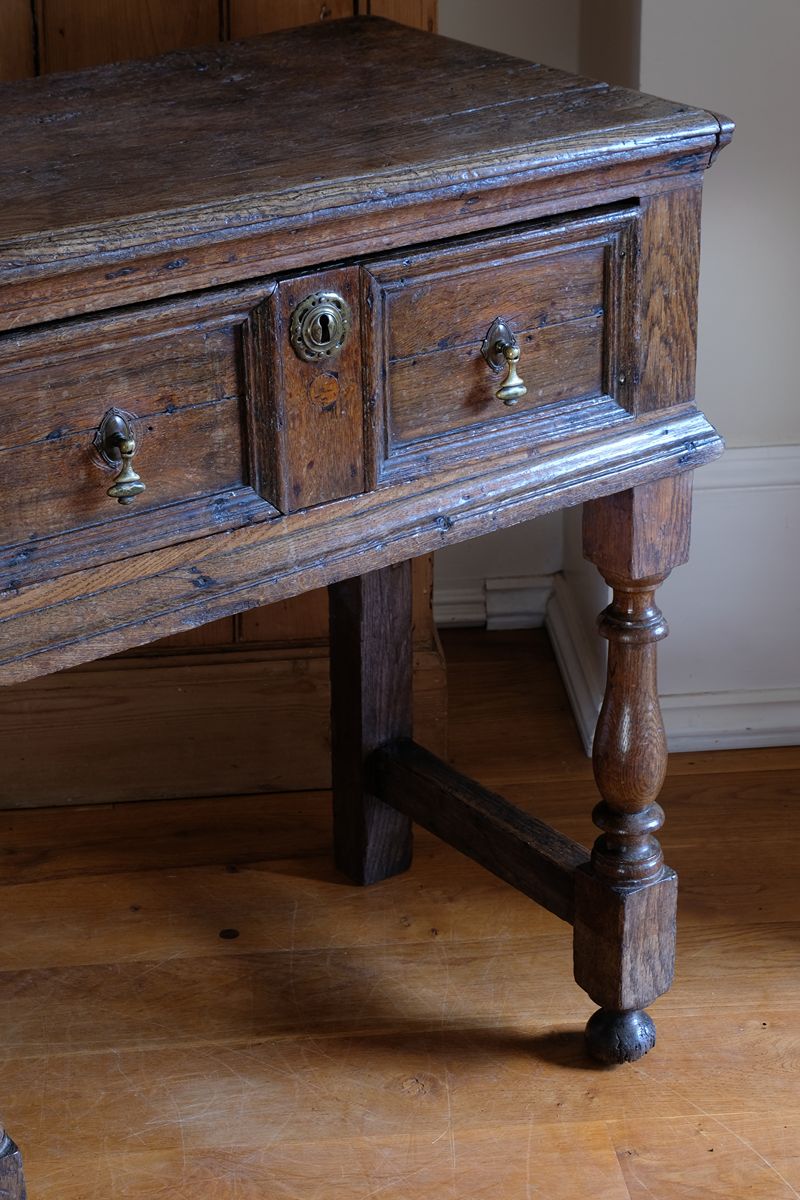 18th century country oak side table with a single panelled drawer, brass handles and baluster-turned front legs