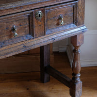 18th century country oak side table with a single panelled drawer, brass handles and baluster-turned front legs