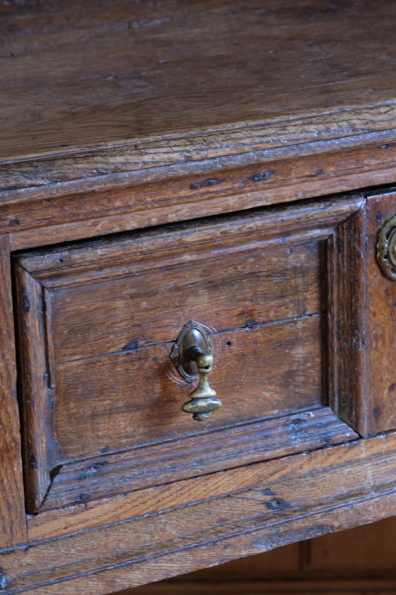 close up of the drawer front - 18th century country oak side table with a single panelled drawer, brass handles and baluster-turned front legs