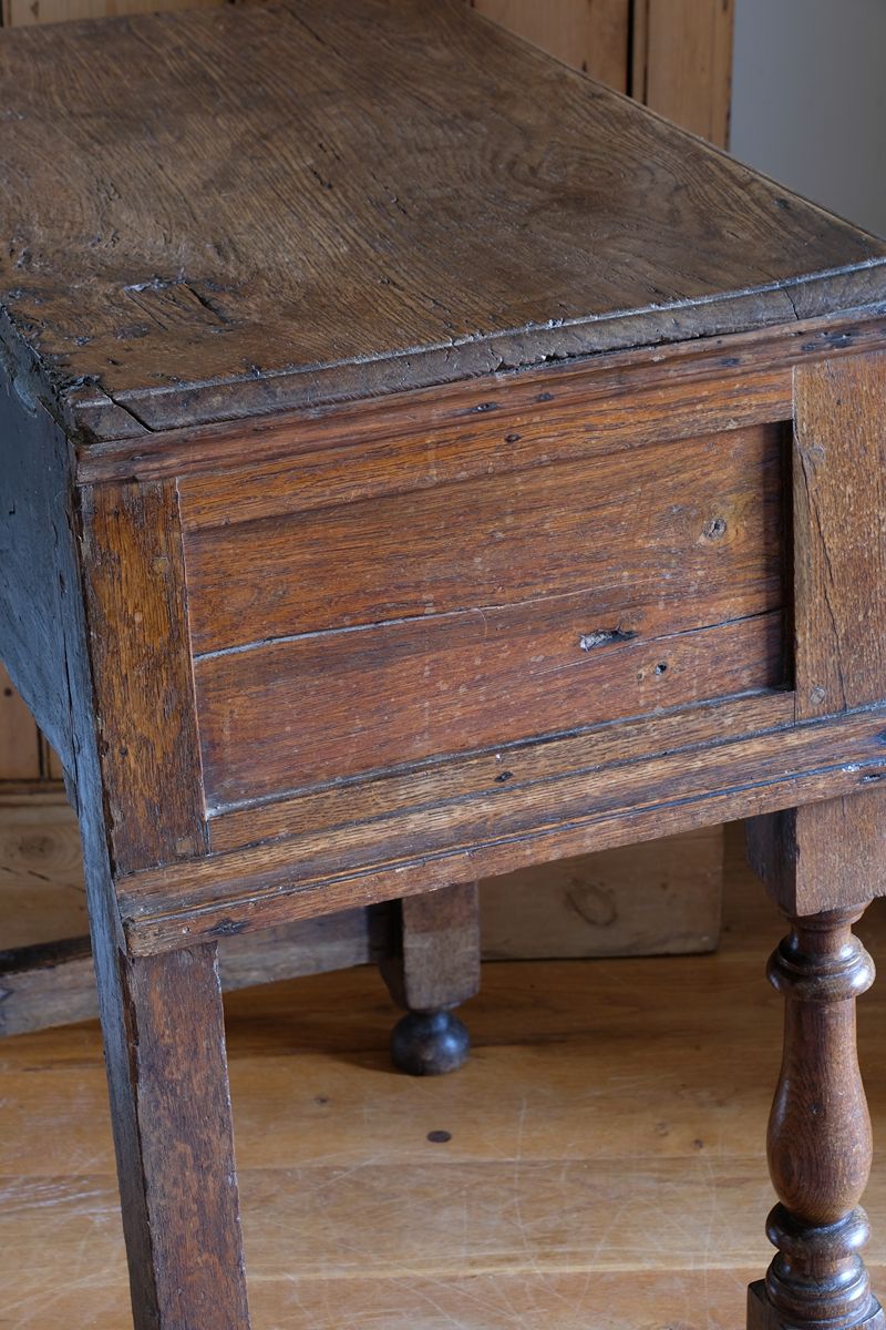 18th century country oak side table with a single panelled drawer, brass handles and baluster-turned front legs