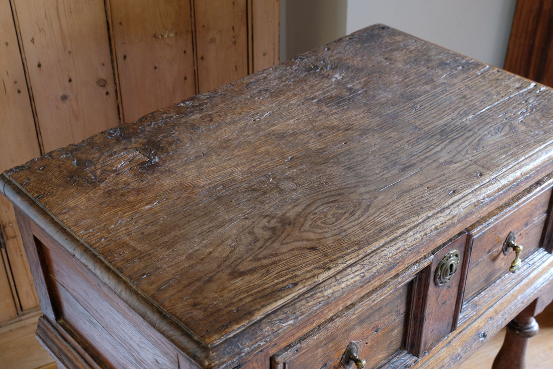 View of the ages wear on the 18th century country oak side table with a single panelled drawer, brass handles and baluster-turned front legs