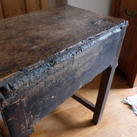 Rear photo showing the thick single board oak panel of the 18th century country oak side table with a single panelled drawer, brass handles and baluster-turned front legs