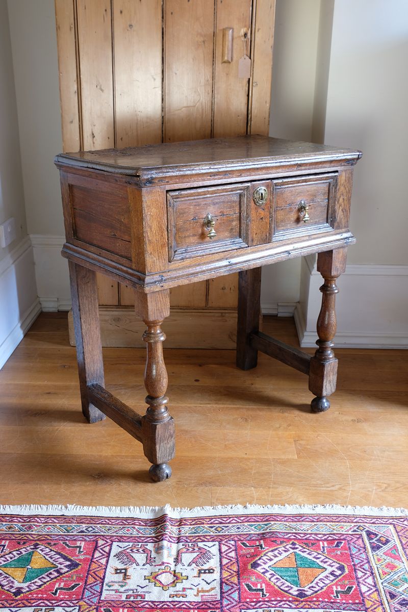 18th century country oak side table with a single panelled drawer, brass handles and baluster-turned front legs